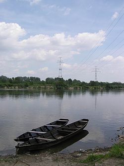 Sungai Vistula di Łomianki Dolne dengan powerline penyeberangan di latar belakang