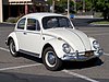 A white volkswagen beetle in a car park