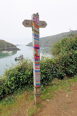 Footpath sign on the Pembrokeshire Coast Path at Solfach, Wales, with yarn bombing