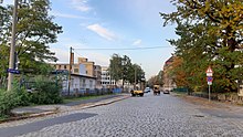 Gepflasterte Straße, in der Mitte eine Pferdekutsche, aber moderne Aufnahme