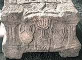 תבליט מנורת שבעת הקנים על רהיט אבן ששימש להנחת ספר תורה מבית הכנסת במגדלא המתוארך למחצית הראשונה של המאה הראשונה לספירה. הממצא הקדום ביותר של מנורת שבעת קנים בבית כנסת