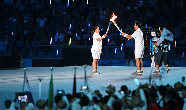 The torch relay during the opening ceremony. South Korean athletes Inbee Park move the fire to Lee Seung-yuop