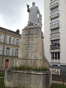 Foto af en stenstatue og dens forbjerg.