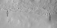 Close view of mantle, as seen by HiRISE under HiWish program Arrows show craters along edge which highlight the thickness of mantle. Mantle may be used as a water source by future colonists. Location is Ismenius Lacus quadrangle.
