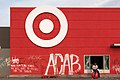 A man sits on a Target ball in front of the store on Thursday morning. The store was looted and graffitied after a night of protests in Minneapolis, Minnesota (49945856206).jpg