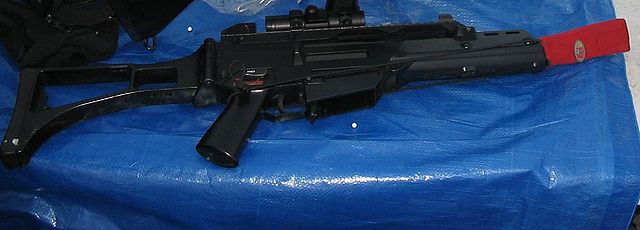 Airsoft replica of an H&K G36C. This replica is not in use on a field, and has the magazine removed, the chamber cleared, and a barrel bag placed over