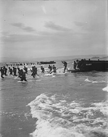 LCVPs from Cepheus bringing troops ashore during an exee in Algeria, April 1944 American troops leap forward to storm a North African beach.jpg