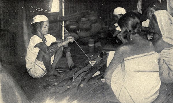 A shaman of the Itneg people in the Philippines renewing an offering to the spirit (anito) of a warrior's shield (kalasag) (1922)