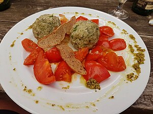 Bergkräuterknödel auf geschmorten Tomaten