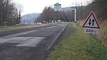 Panneau A18 complété par un panonceau de distance M1