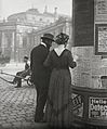 Forbipasserende ser teaterprogrammer på en udstillingssøjle nær Burgtheater i Wien, Østrig, fotograferet af Emil Mayer i det tidlige 20. århundrede.