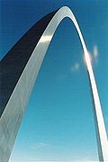 The arch rises from the bottom left of the picture and is shown against a featureless clear sky