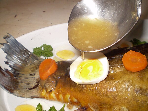 Pouring fish stock on a stuffed fish