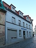 Residential house with shop fitting, in closed development