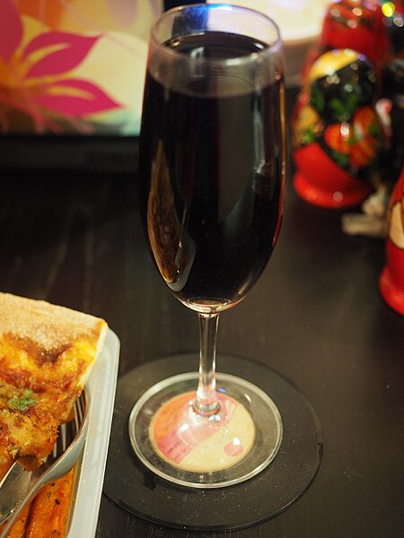 File:Glass of red wine on coaster.jpg