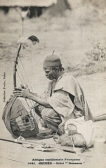 A Susu yeliba playing a three-string bolon in 1905. Griot Soussou (Guinee).jpg