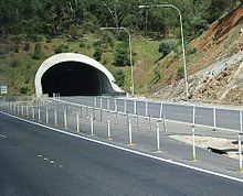 Straße, die aus der schwarzen Öffnung eines Tunnels herausführt