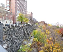 Soldaki Columbia Üniversitesi binaları, parkta Morningside Drive'daki Columbia Üniversitesi binalarında Morningside Park'a bakan ağaçlı bir alana bakıyor