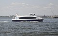 A NYC Ferry boat seen on the water from Brooklyn Bridge Park, New York City.