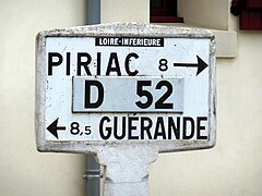 Photographie d'un panneau de signalisation blanc indiquant les directions de Guérande et de Piriac-sur-Mer sur la D 52.
