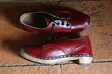 Traditional Gibson style English clogs made in Lancashire. Similar style clogs are made throughout the Kingdom. Note the plastic soling to protect the wood from wear. Red Lancashire clogs (side view).jpg