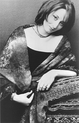 photo noir et blanc d'une femme aux cheveux mi-longs, avec une robe et un châle autour des épaules