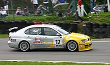 Huff driving for SEAT at Brands Hatch during the 2004 British Touring Car Championship season. Rob Huff - SEAT Toledo Cupra exits Druids Hill Bend, Brands Hatch at the BTCC on 25-04-2004 (50887468076).jpg