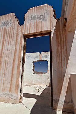 View through a ruin door and window to the blue sky above the Namib desert.