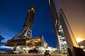 The Space Launch System mobile launch platform and tower being moved by the crawler transporter to the Vehicle Assembly Building at Kennedy Space Center.