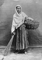 Studio portrait of young woman with basket and broom, India (c. 1921).jpg