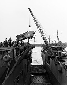 USS Kitty Hawk (AKV-1) offloading a Grumman F4F-4 Wildcat fighter to USS Long Island (CVE-1) in August 1942. USS Kitty Hawk (APV-1) lifting aircaft aboard USS Long Island (ACV-1) off Fila Island, New Hebrides, 28 August 1942 (80-G-73394).jpg