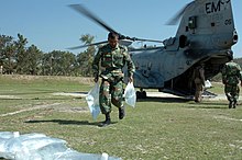 Humanitarian operation after Cyclone Sidr 2. US Navy 071126-N-1831S-104 A member of the Bangladesh Army helps unload bags of purified water from a CH-46 Sea Knight assigned to the amphibious assault ship USS Kearsarge (LHD 3).jpg