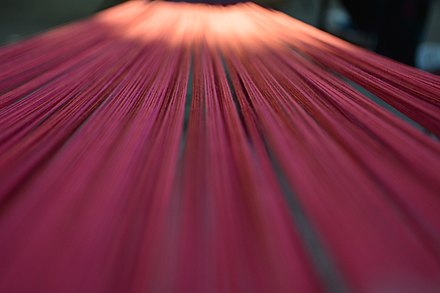 In textile production, longitudinal yarns are referred to as warp and are interlaced with weft or filing yarns to create a woven fabric.