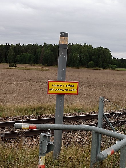 E-signal on Dalabanan, just west of Uppsala. The sign states: "Do not pass the track, when light is extinguished."