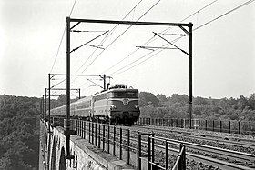 BB 16052 na czele pociągu pasażerskiego na wiadukcie.