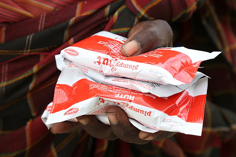 File:18-month-old James and his mother Margaret, pictured with a supply of sachets og Plumpy Nut, a Ready to Use Therapeutic Food used to treat acute maluntrition, Turkana County, northern Kenya, 28 March 2017 (33140342933).jpg