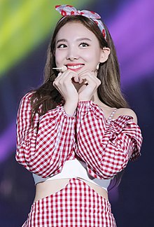 Nayeon se usměje a vytvaruje si ruce do srdce