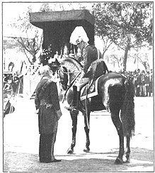 Maura conversing with the monarch in April 1909; photograph by Campua. Alfonso XIII hablando con Antonio Maura durante la ceremonia de la jura de la bandera en el Paseo de la Castellana, de Campua.jpg