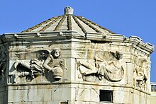 Reliefs of Zephyrus and Skiron; three of the sundials are in the sun Atenas, Torre de los Vientos 2.jpg