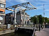 Jan Verzwollebrug. Ophaalbrug, voormalige spoorbrug uit 1914 over de Karnemelksloot in Gouda. Het Schoonhoofse spoortje (SS Gouda-Schoonhoven) heeft 27 jaar bestaan (14 november 1914 tot 1942). Bij de Jan Verzwollebrug in Gouda stond het begin station, verdere haltes waren: Karnemelksloot, Stolwijkersluis, Beijersche weg, Stolwijk, Koolwijk, Huisweg, Bergambacht, Ammerstol, Den Hem en eindstation Schoonhoven.