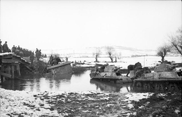 German forces with French-made H39 tanks fording a river.