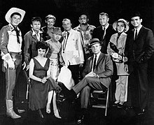 Guest stars for the 1961 premiere episode of The Dick Powell Show, "Who Killed Julie Greer?". Standing, from left: Ronald Reagan, Nick Adams, Lloyd Bridges, Mickey Rooney, Edgar Bergen, Jack Carson, Ralph Bellamy, Kay Thompson, Dean Jones. Seated, from left, Carolyn Jones and Dick Powell. Dick Powell Show Premiere Episode 1961.JPG