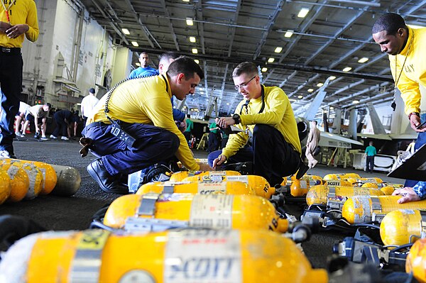 Sailors check breathing devices at sea.