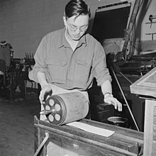 Bill Hosokawa pulling a galley proof while working as a newspaper editor in the Heart Mountain Relocation Center, 1943 Heart Mountain Relocation Center, Heart Mountain, Wyoming. In the press room of the Cody Enterprise . . . - NARA - 539218.jpg