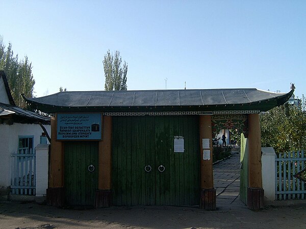 The gate of the Dungan mosque in Karakol, Kyrgyzstan. The upper text on the sign is a partially Uyghurized rendering of the mosque's Kyrgyz name into 