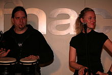 Deux musiciens habillés de noir devant un mur marqué Fnac