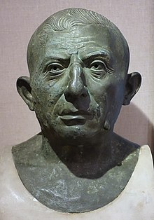 Bronze head statue of an ageing, bald man, with a conspicuous facial wart.