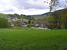 Blick über den Ortskern von Markersbach mit der St.-Barbara-Kirche zur Staumauer des Pumpspeicherwerks