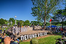 A "defund police" sign and stage before a rally at Powderhorn Park on June 7, 2020. Minneapolis City Council Pledges to Dismantle Police Department.jpg