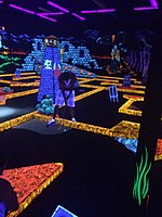 Golfer golfing at Monster Mini Golf, an indoor glow in the dark mini golf course Monster Mini Golf Glow in the Dark Golfer.jpg